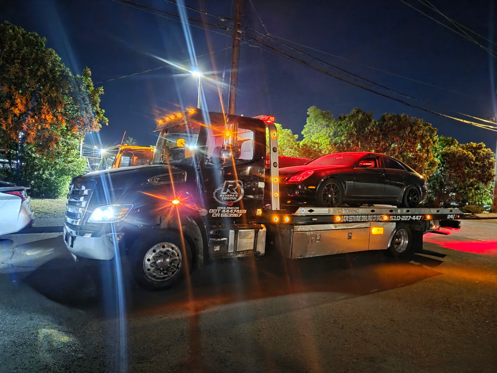 Mercedes CLS coupe loaded at night with full lights on Rivera's flatbed