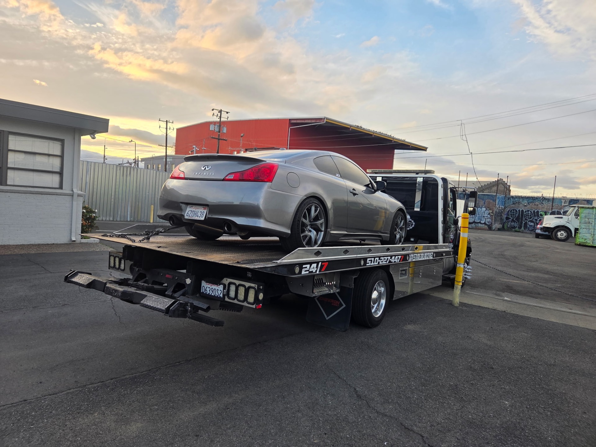 Infiniti G37 coupe loaded onto Rivera's flatbed at sunset in Oakland